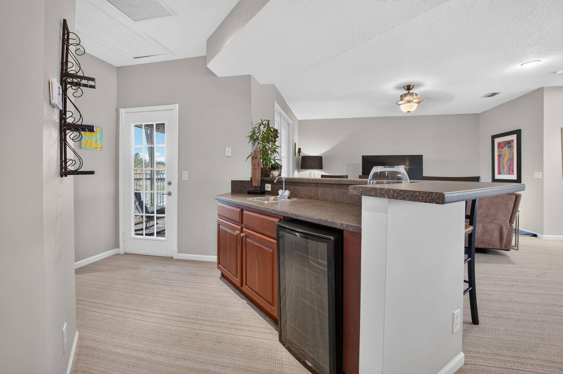 6610 Aston Lane, Boynton Beach, FL 33437 Built-in wet bar with dark wood cabinetry, integrated beverage refrigerator, and stone-finish countertop