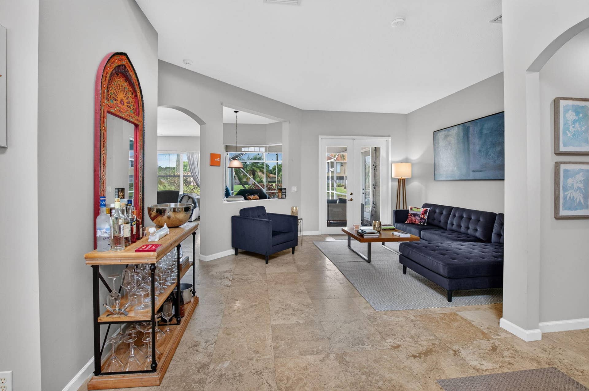 6610 Aston Lane, Boynton Beach, FL 33437 Neutral tone wall paint, arched doorway, tile flooring, and double French doors to the exterior