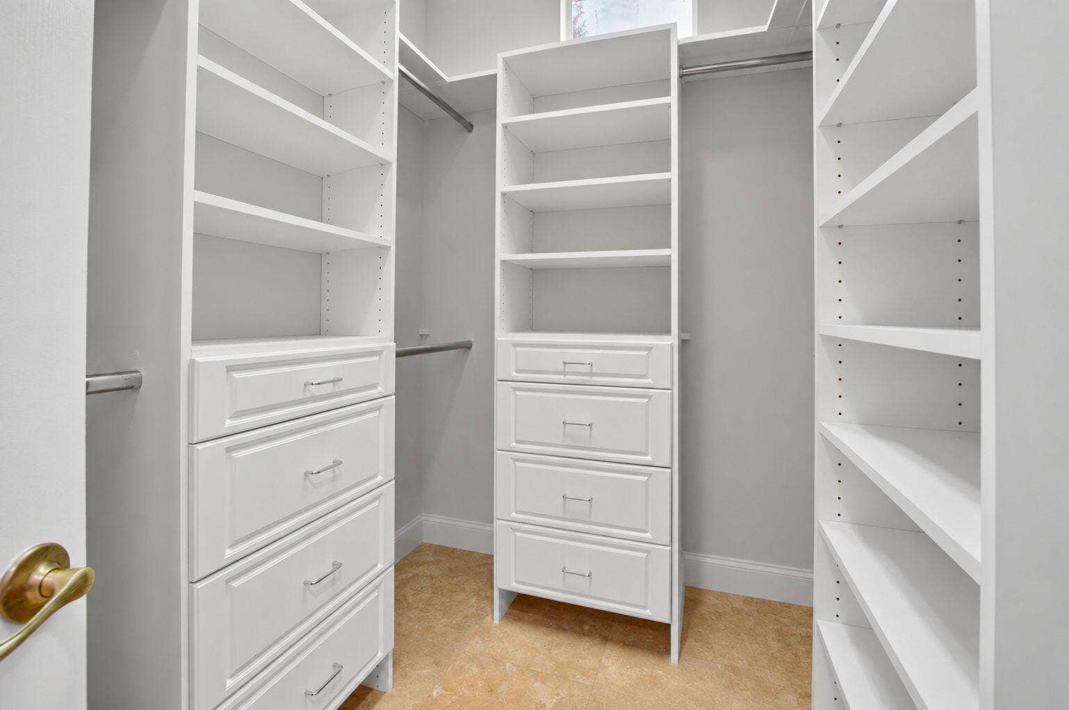 6610 Aston Lane, Boynton Beach, FL 33437 Custom closet system featuring white built-in shelving, integrated drawers with brushed nickel hardware, and multiple clothing rods