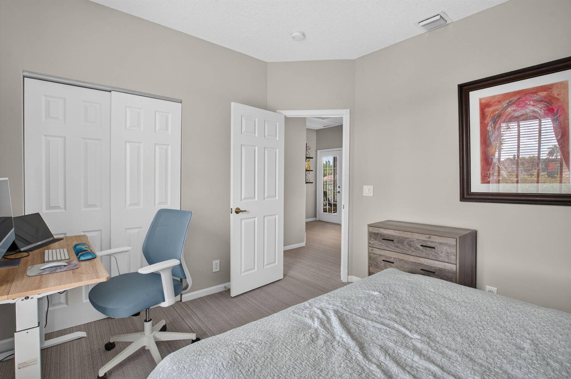 6610 Aston Lane, Boynton Beach, FL 33437 Neutral-toned walls, wood-finish flooring, white paneled doors, and an open doorway leading to an exterior space