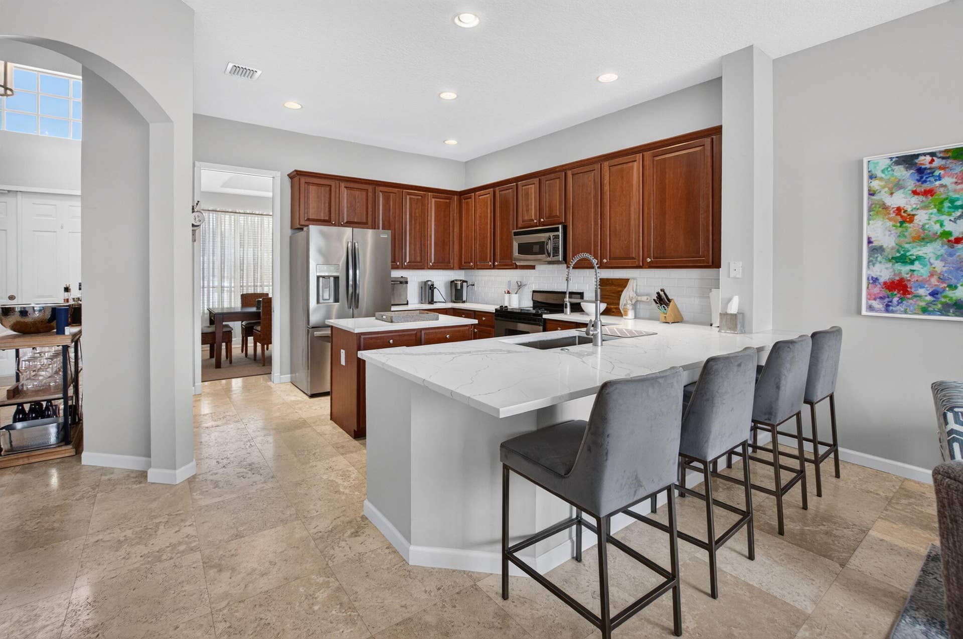 6610 Aston Lane, Boynton Beach, FL 33437 Kitchen featuring wood cabinetry, stainless steel appliances, a large island with a surface, and light-toned flooring