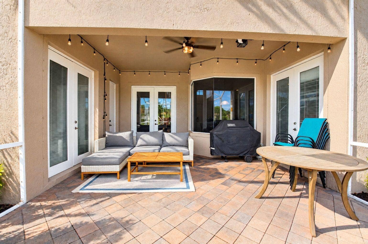 6610 Aston Lane, Boynton Beach, FL 33437 Covered patio featuring paver flooring, multiple sets of double French doors, and a ceiling fan