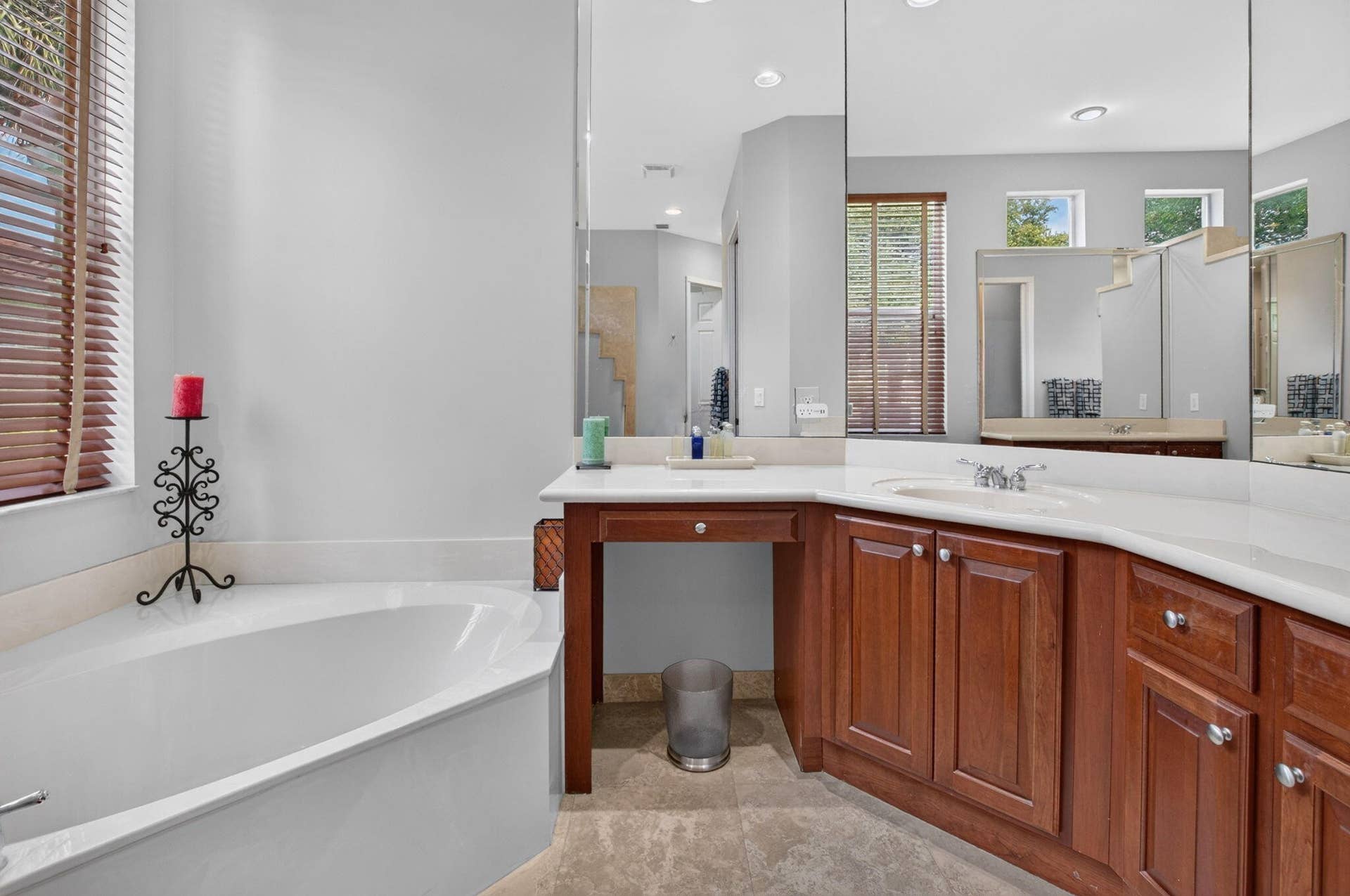 6610 Aston Lane, Boynton Beach, FL 33437 Built-in bathtub, dual vanity with undermount sinks, wood-finish cabinetry, and a full-height wall mirror