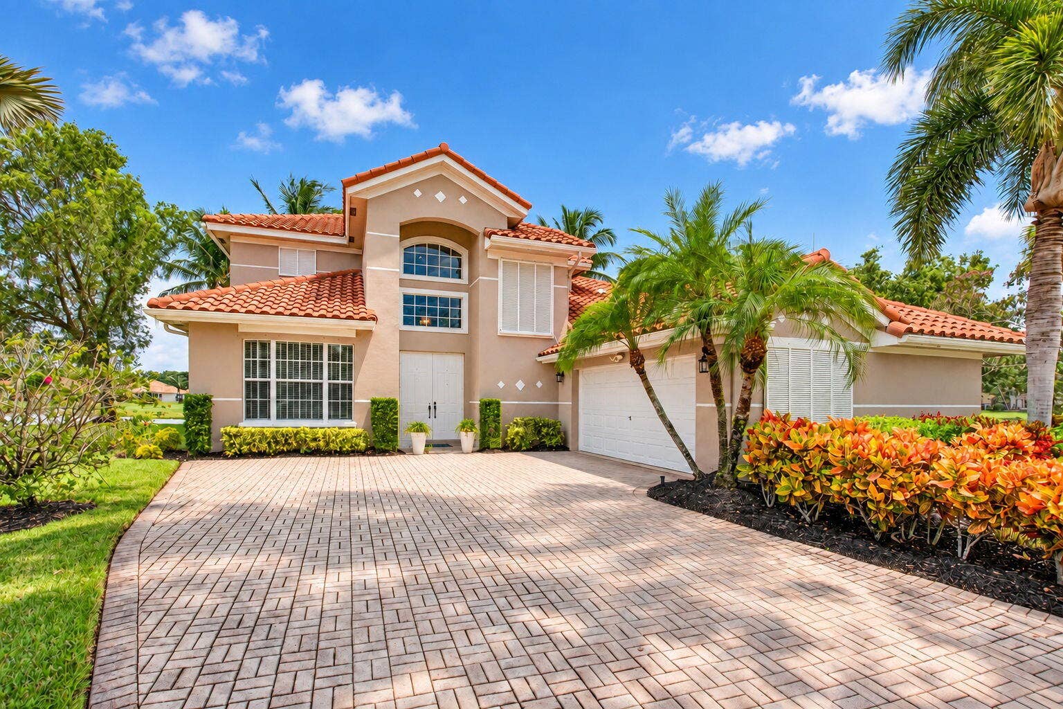 6610 Aston Lane, Boynton Beach, FL 33437 Mediterranean-style residence featuring a tile roof, stucco exterior, and a paver driveway