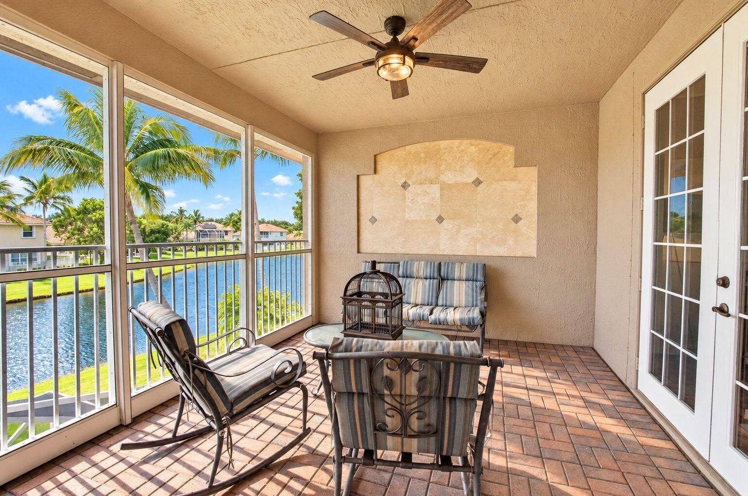 6610 Aston Lane, Boynton Beach, FL 33437 Expansive enclosed patio featuring brick-pattern flooring and a ceiling fan