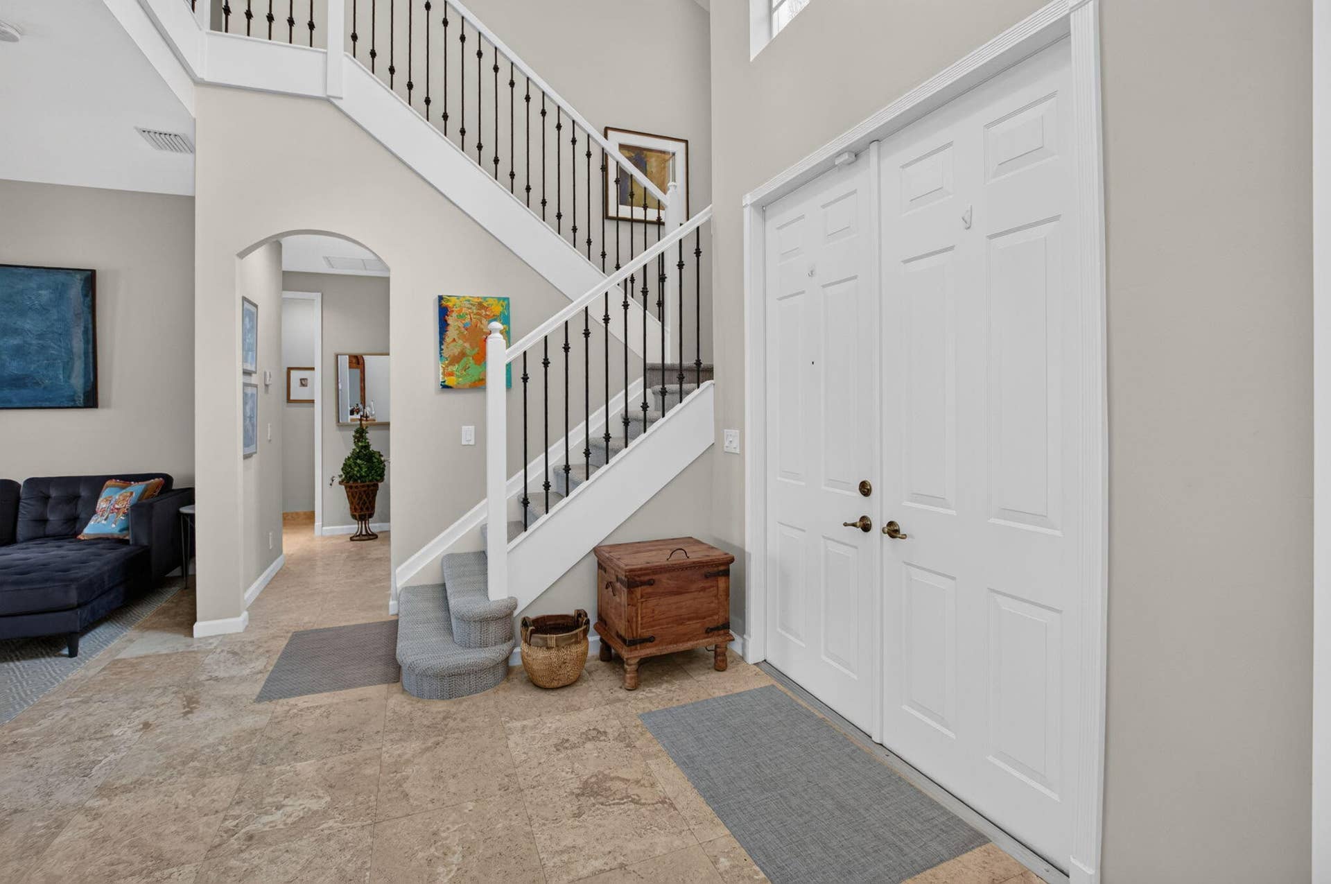 6610 Aston Lane, Boynton Beach, FL 33437 Double entry doors with brass hardware, tile flooring, a staircase with black iron spindles, and an arched doorway