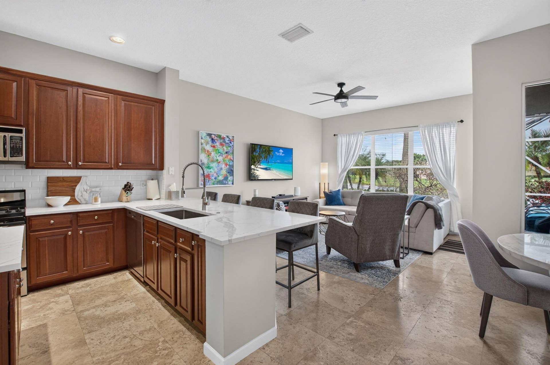 6610 Aston Lane, Boynton Beach, FL 33437 Kitchen featuring wood cabinetry, white subway tile backsplash, and light-toned countertops
