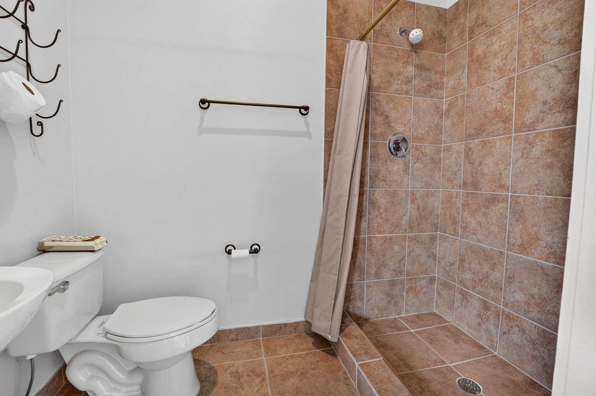 6610 Aston Lane, Boynton Beach, FL 33437 Walk-in shower with full-height tile surround and floor, white toilet, and bronze-finish fixtures