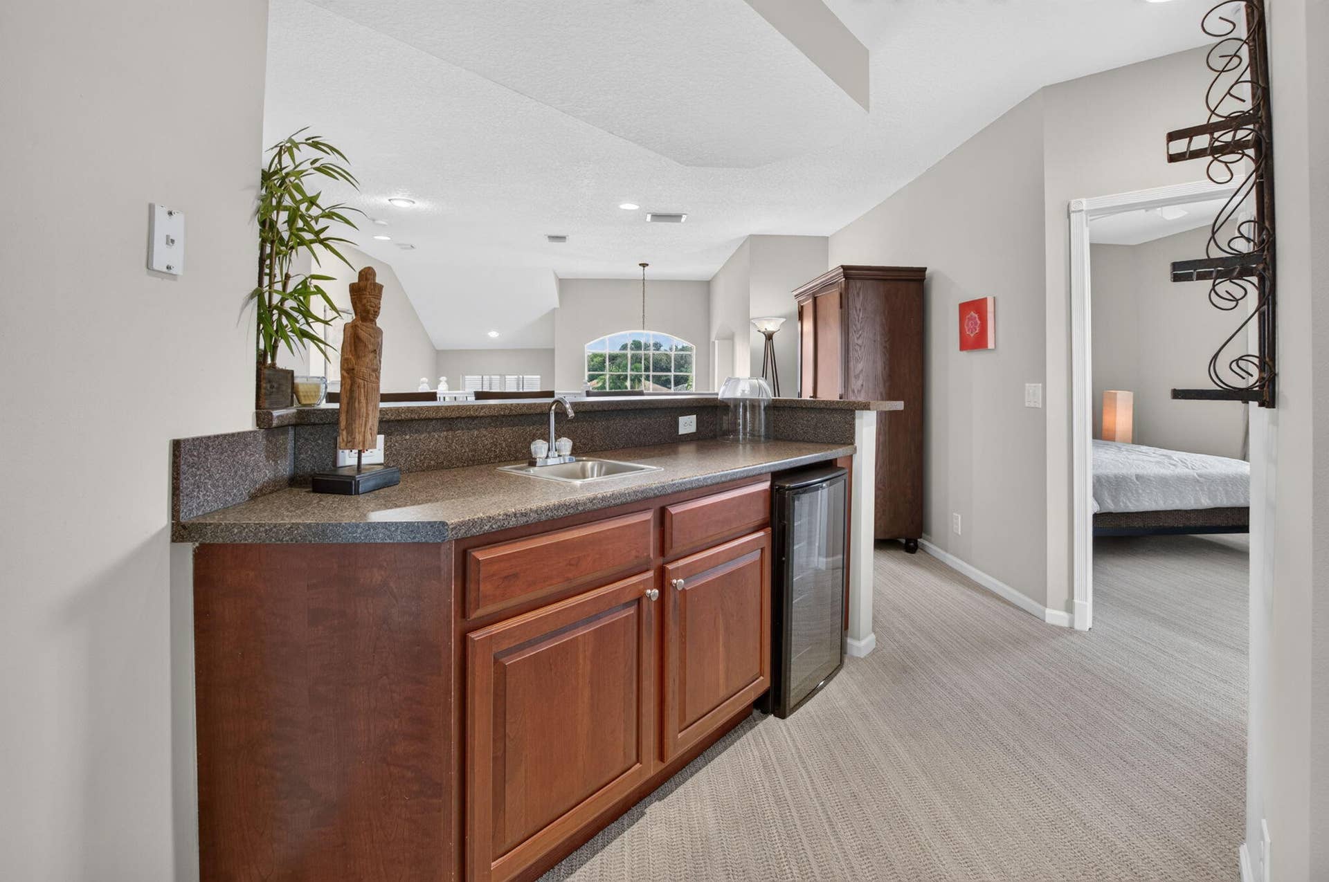 6610 Aston Lane, Boynton Beach, FL 33437 Built-in wet bar with wood-finish cabinetry, integrated sink, and stone-finish countertop