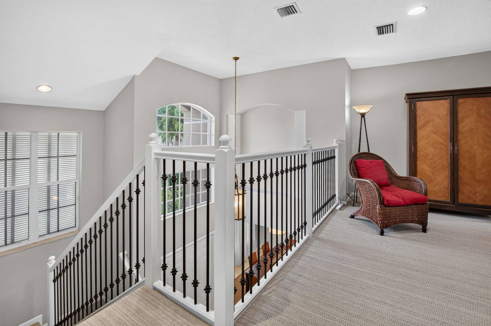 6610 Aston Lane, Boynton Beach, FL 33437 Upper level landing featuring carpeted flooring, white and black metal balustrade, recessed lighting, and an arched window