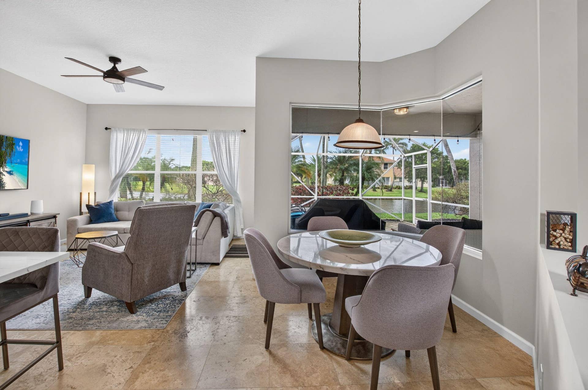6610 Aston Lane, Boynton Beach, FL 33437 Travertine-style flooring, a dining area with a bay window, and a ceiling fan in the living space