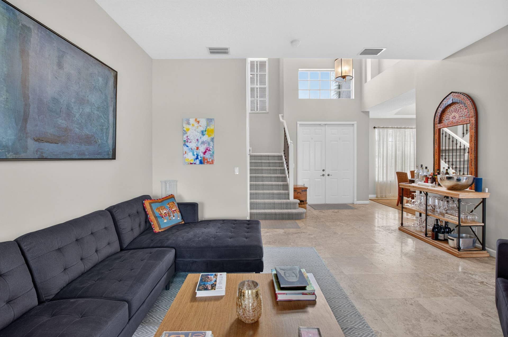 6610 Aston Lane, Boynton Beach, FL 33437 Two-story foyer with transom window, double entry doors, staircase with carpeted treads, and stone tile flooring