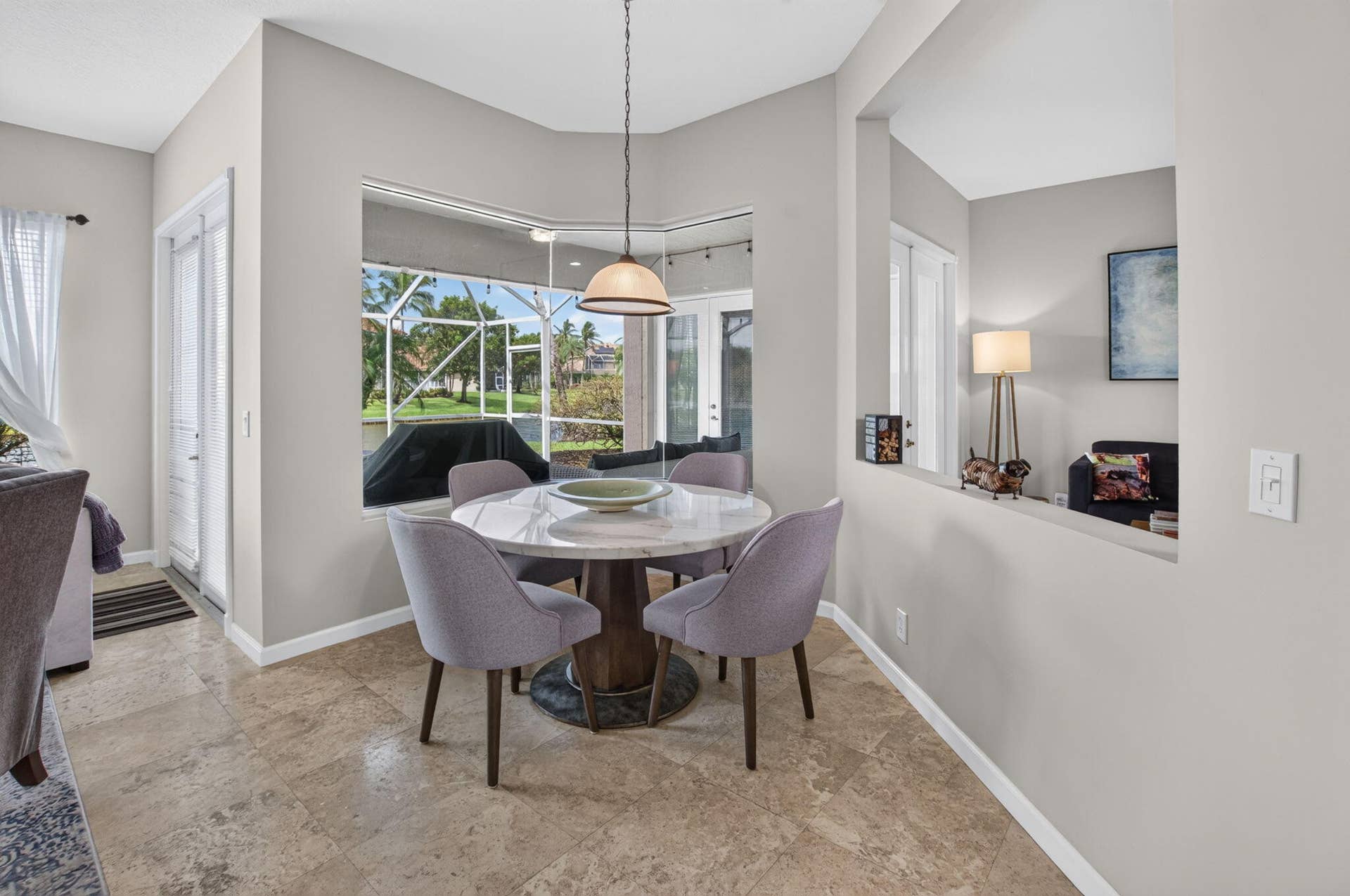 6610 Aston Lane, Boynton Beach, FL 33437 Bay window with screened enclosure, a built-in pass-through, pendant lighting, and tile flooring