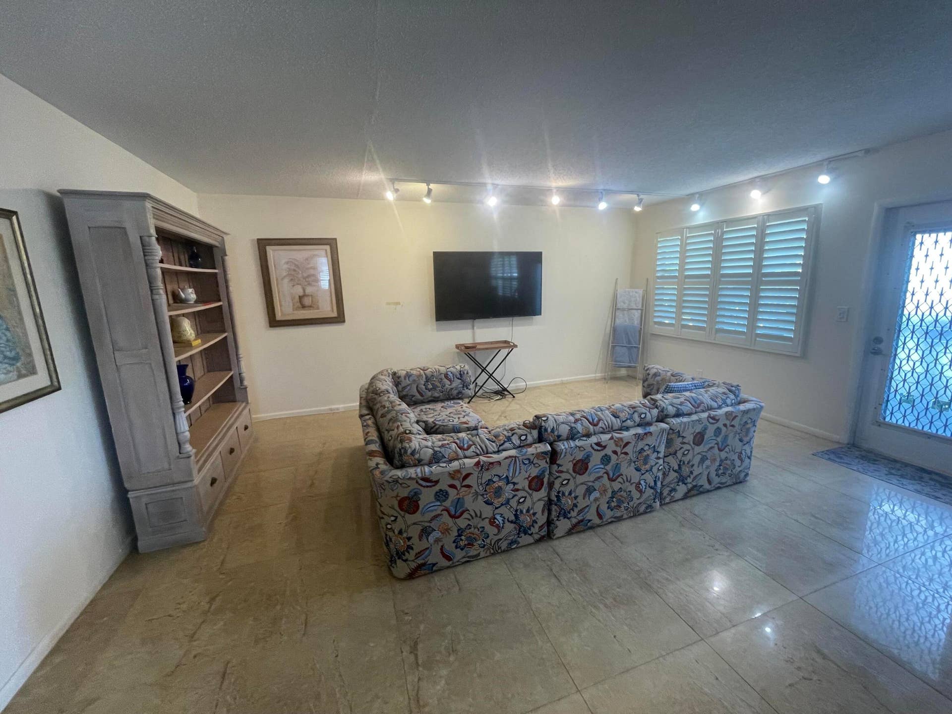 Living Room with Large Porcelain Tile & Bahama Shutters