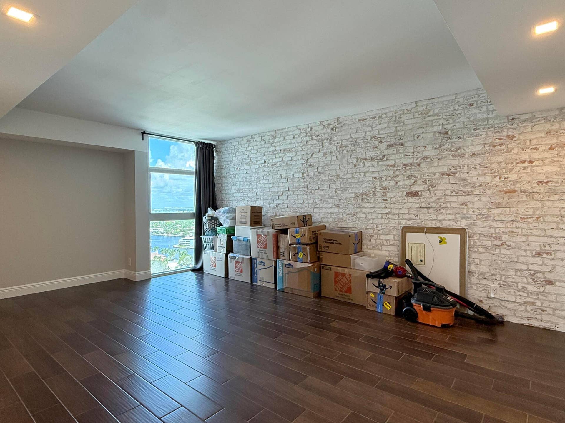Spacious primary with brick accent wall