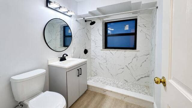 560 NE 15th Avenue, Fort Lauderdale, FL 33301 Walk-in shower with marble-look wall tile and pebble floor tile. Virtually staged.