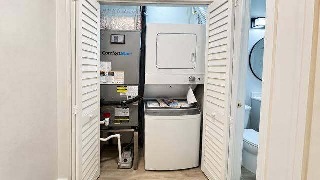 560 NE 15th Avenue, Fort Lauderdale, FL 33301 Louvered bi-fold doors enclosing a stacked washer and dryer unit. Virtually staged.
