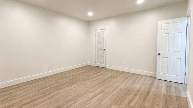 560 NE 15th Avenue, Fort Lauderdale, FL 33301 Recessed lighting, wood-finish flooring, white trim, and a white six-panel door. Virtually staged.