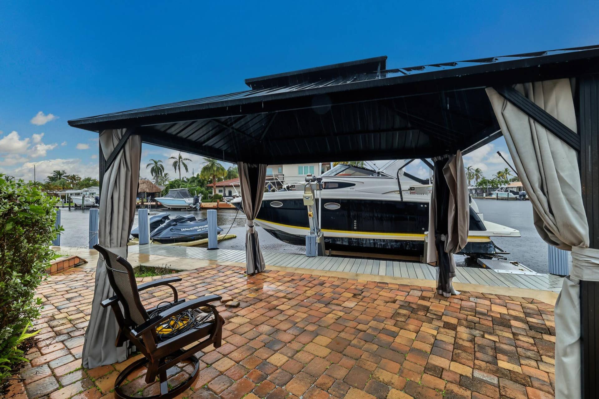 1311 SE 4TH Avenue, Pompano Beach, Pompano Beach, FL 33060 Brick paver patio featuring a black metal gazebo with retractable privacy curtains and a waterfront dock with boat access
