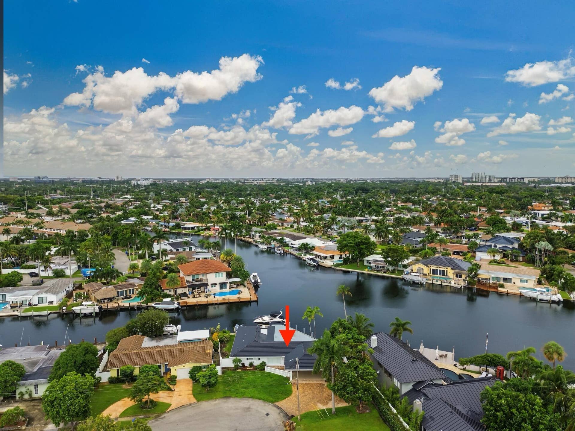 1311 SE 4TH Avenue, Pompano Beach, Pompano Beach, FL 33060 Waterfront property featuring a private boat dock, lush green landscaping, and a circular driveway