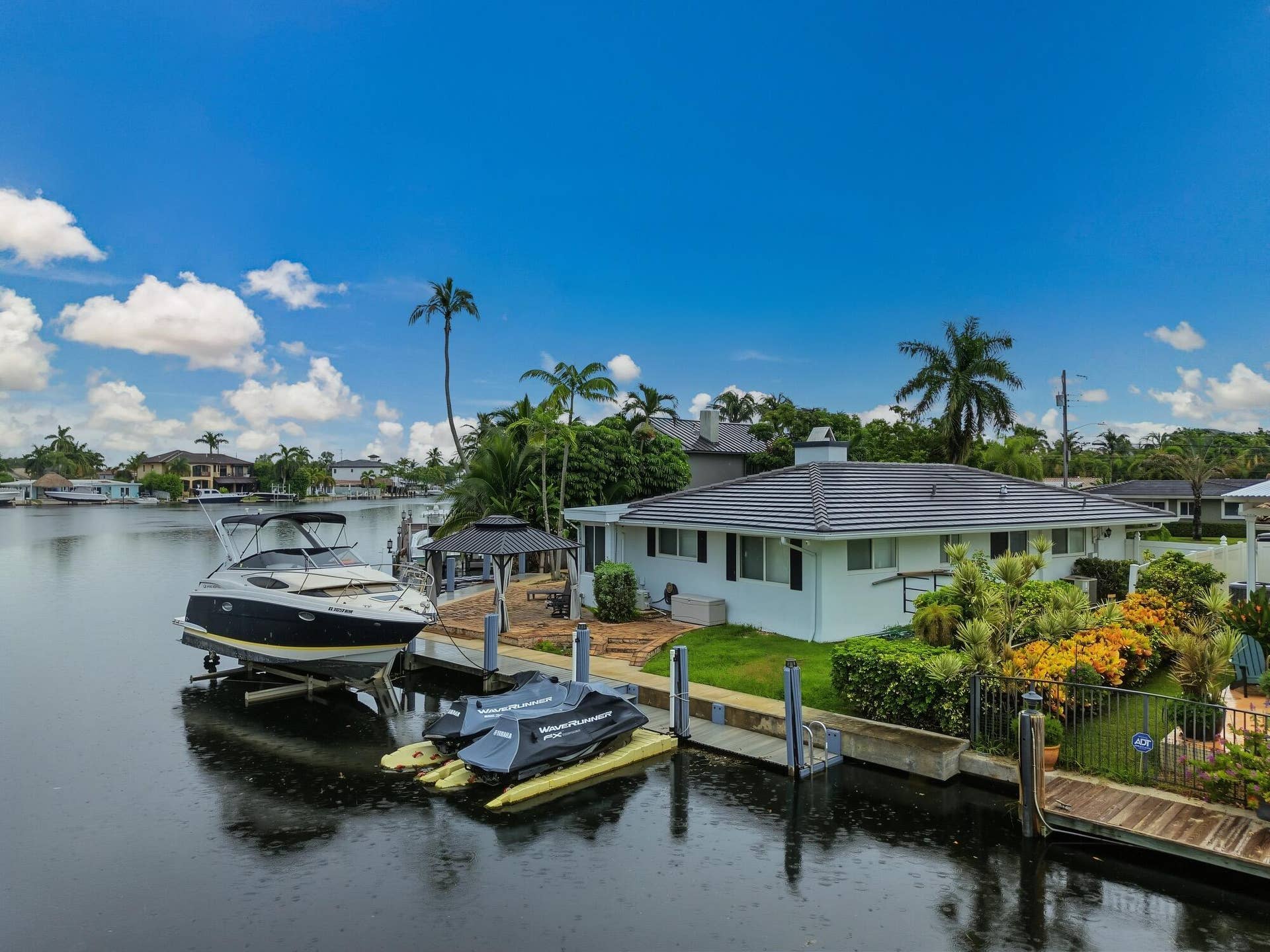 1311 SE 4TH Avenue, Pompano Beach, Pompano Beach, FL 33060 Waterfront property featuring a private boat lift, multiple docking stations, a waterside gazebo, and mature tropical landscaping