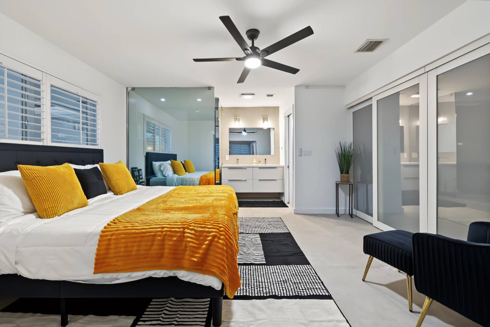 1311 SE 4TH Avenue, Pompano Beach, Pompano Beach, FL 33060 Room featuring a ceiling fan, white plantation shutters, glass partition, sliding opaque closet doors, and wood-finish flooring