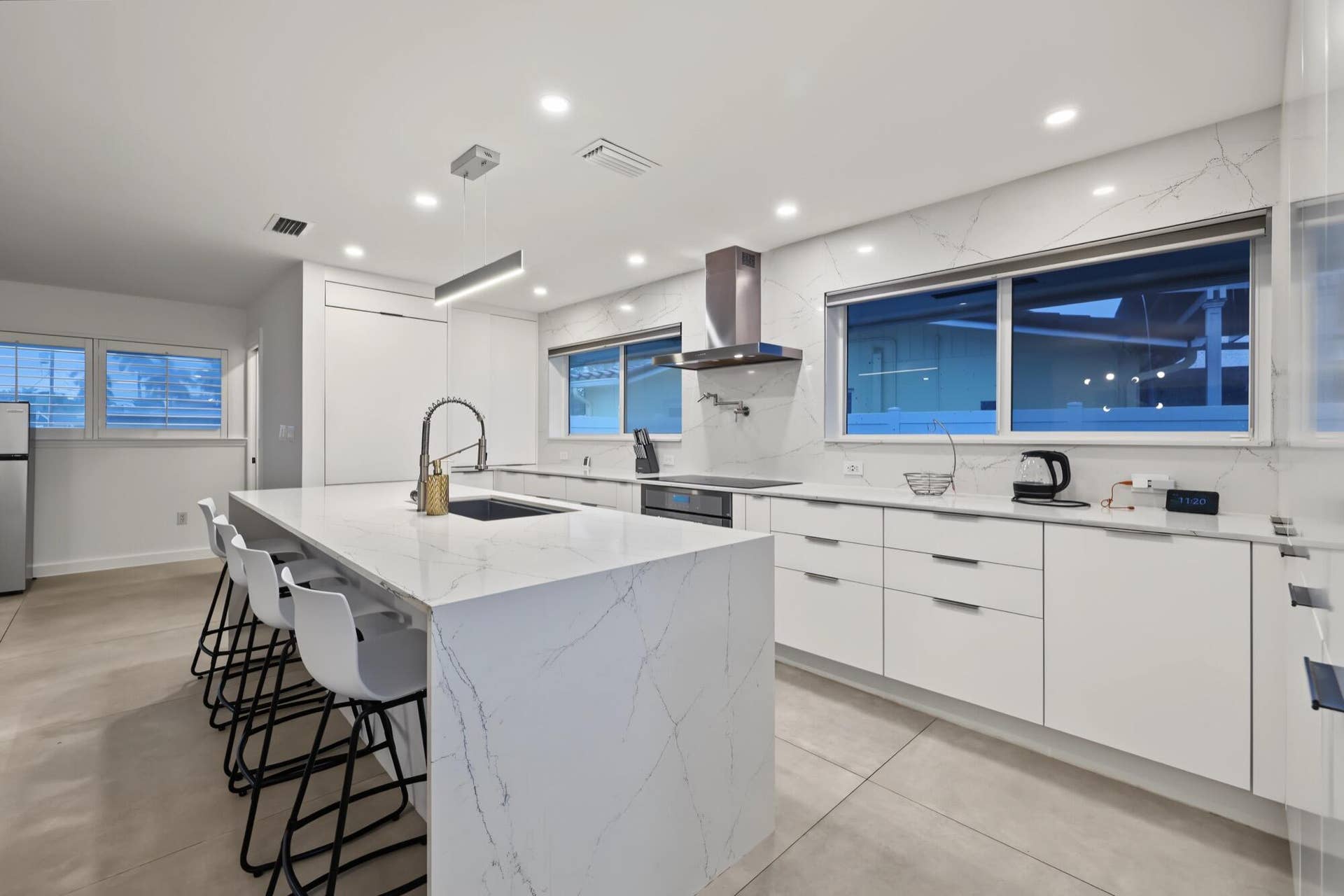 1311 SE 4TH Avenue, Pompano Beach, Pompano Beach, FL 33060 Spacious kitchen featuring a waterfall island, white flat-panel cabinetry, integrated stainless steel appliances, a stainless steel range hood, and recessed lighting
