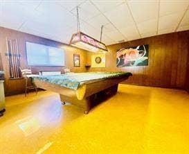 Wood-paneled walls with a suspended lighting fixture and luminous flooring