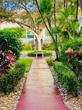 Manicured landscaping with a paved pathway, mature trees, and lush greenery