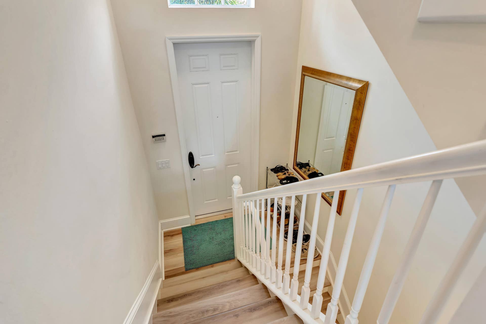 471 JUNO DUNES Way, Juno Beach, FL 33408 Stairway with wood-finish treads and white risers, featuring a white balustrade