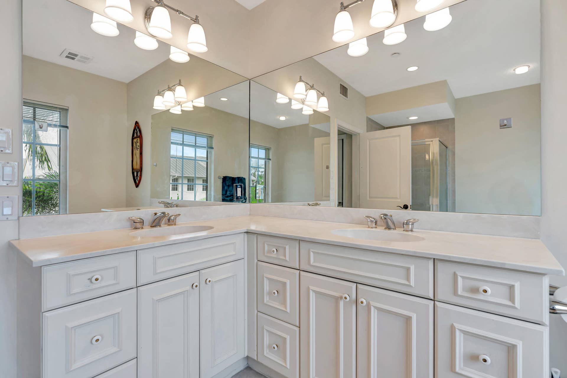 471 JUNO DUNES Way, Juno Beach, FL 33408 Dual vanity with white cabinetry, integrated sinks, white countertops, and expansive wall mirrors