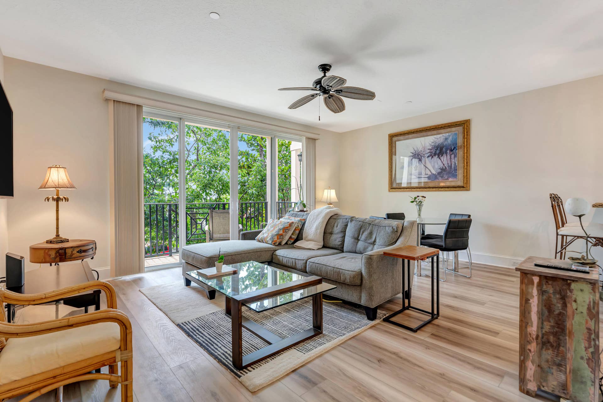 471 JUNO DUNES Way, Juno Beach, FL 33408 Living area with wood-finish flooring, a ceiling fan, and sliding glass doors opening to a balcony with black metal railings