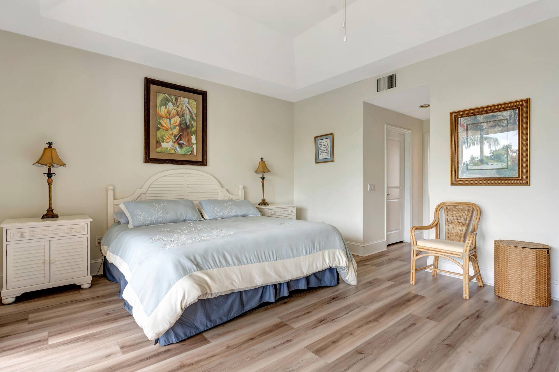 471 JUNO DUNES Way, Juno Beach, FL 33408 Vaulted ceiling, wood-finish flooring, white paneled door, and neutral wall tones