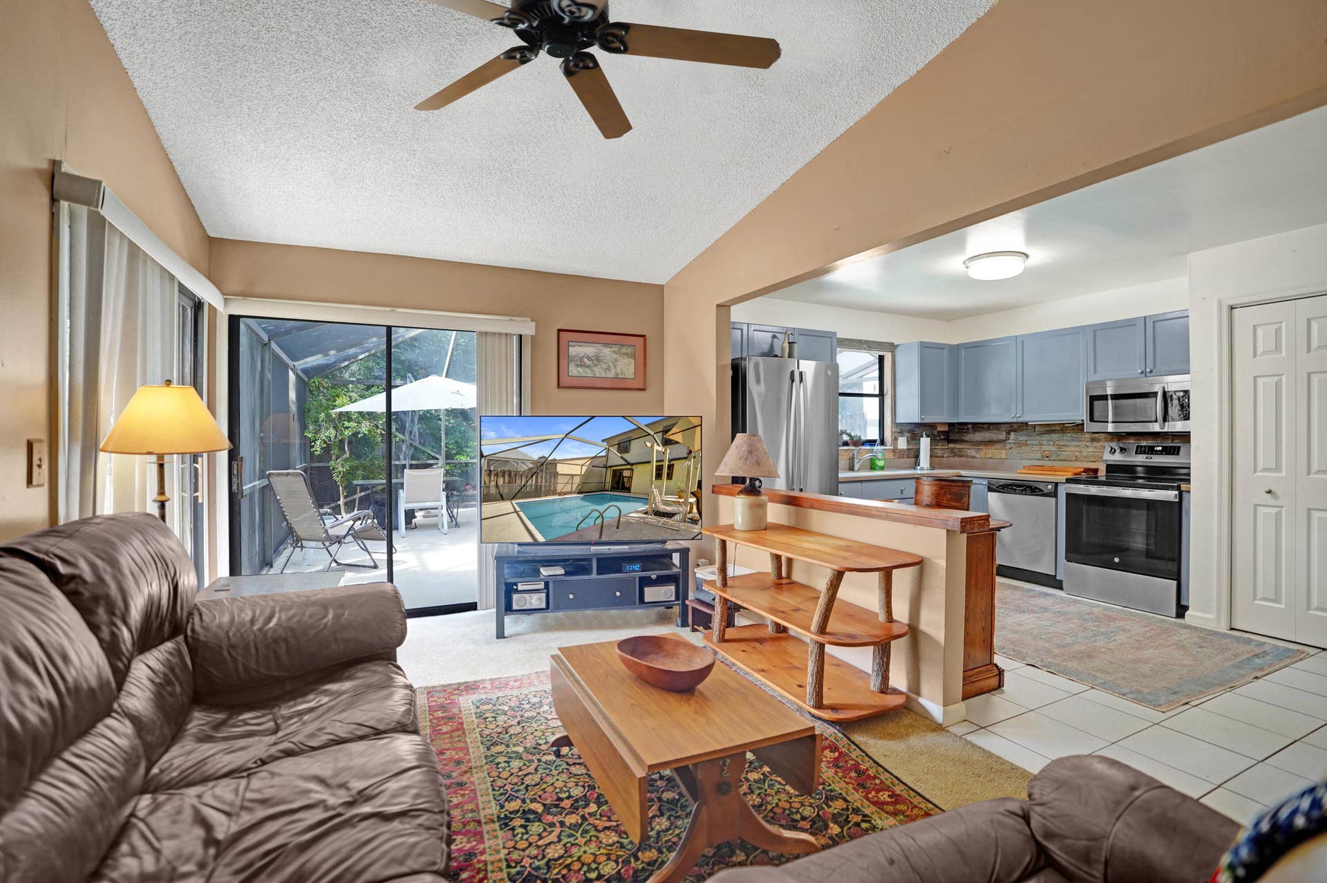 View of family room open to kitchen with sliders leading to private back and pool area.