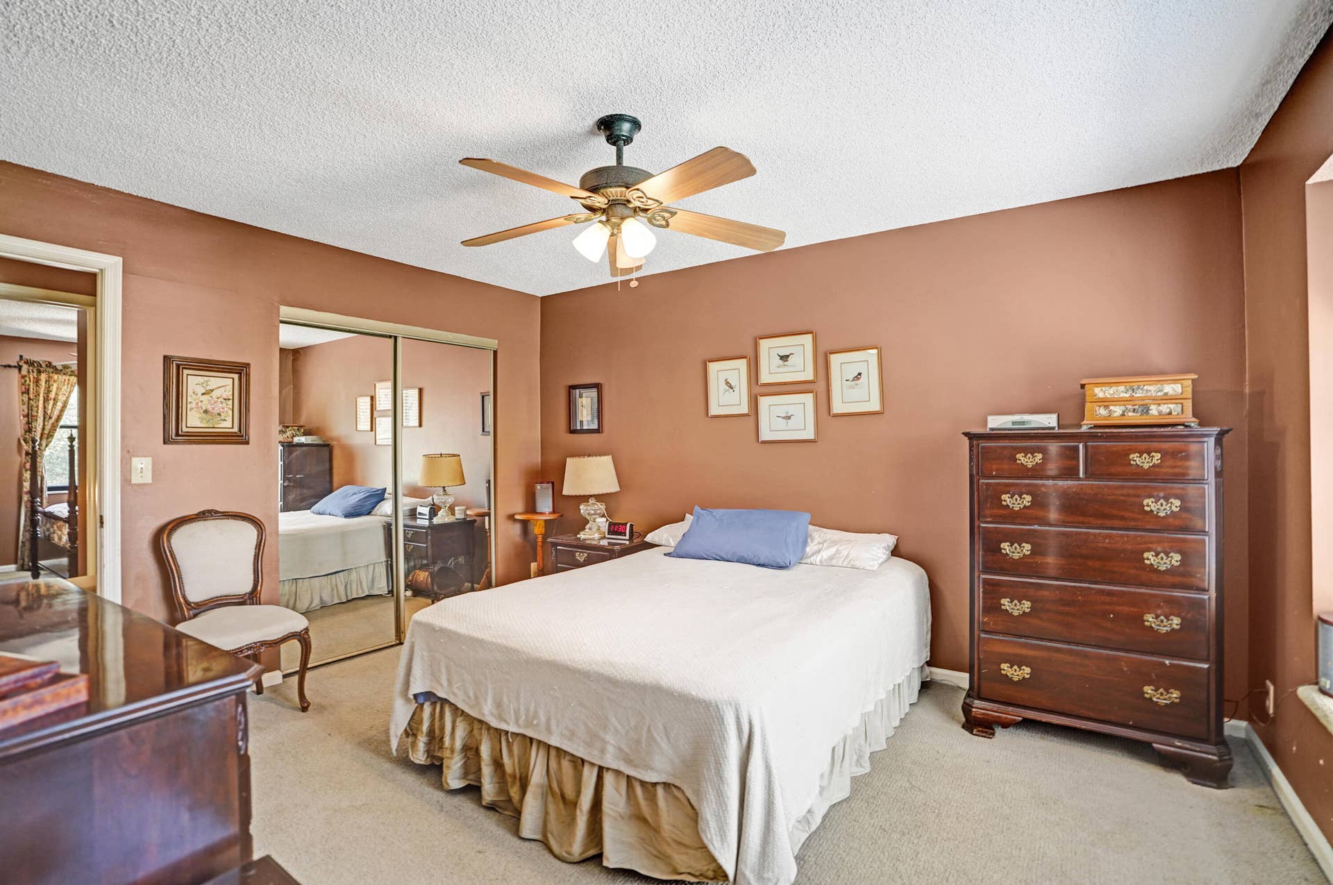 Another view of primary bedroom with closet that offers built in shelving.