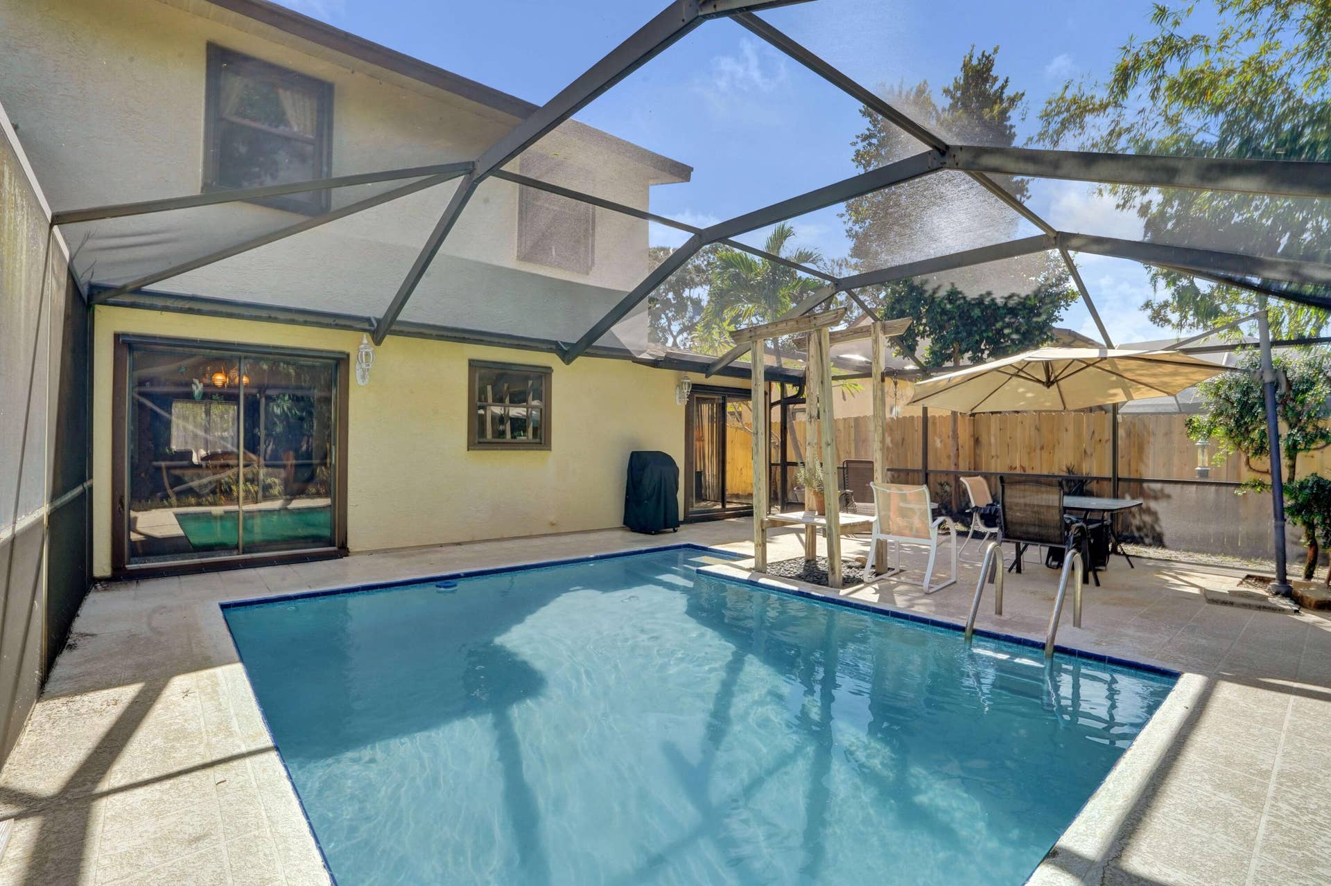 Peaceful back offers screened enclosure and in ground pool