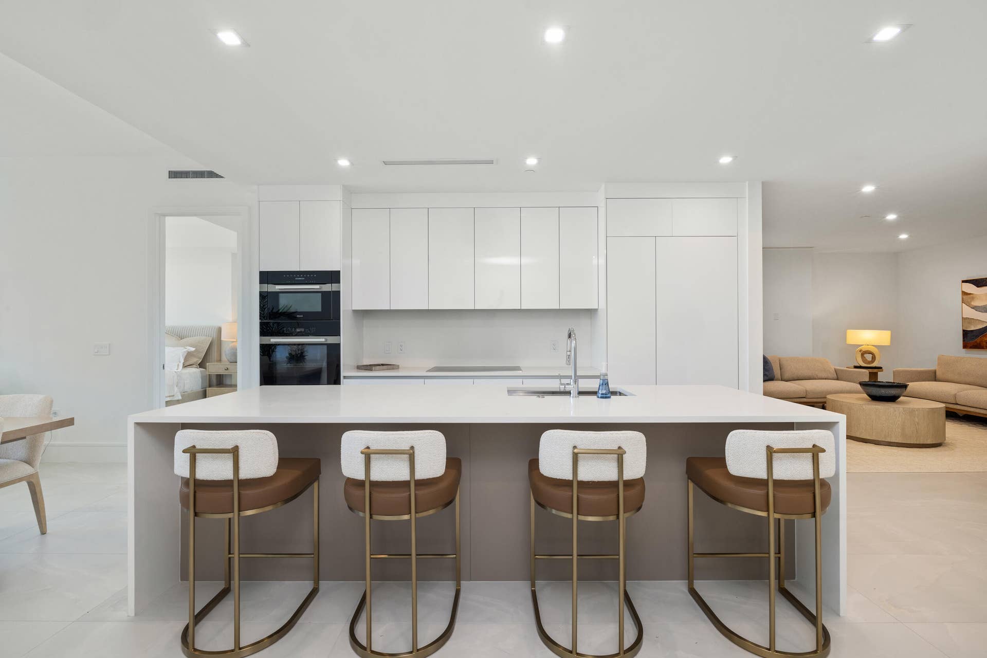 220 Lake Shore Drive, #704, Lake Park, FL 33403 Spacious kitchen island with an integrated sink and light-toned countertop, built-in double ovens, and white flat-panel cabinetry