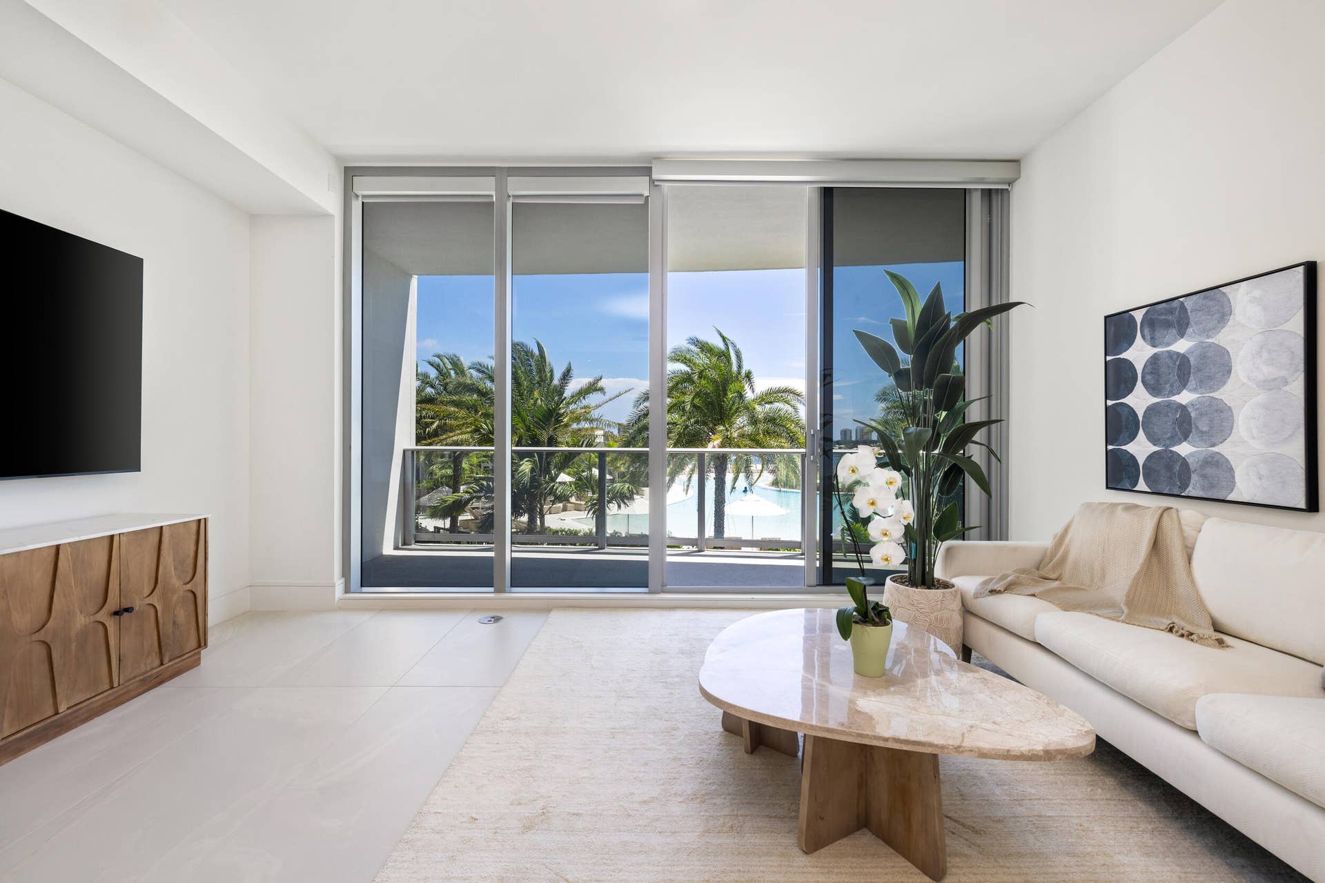 220 Lake Shore Drive, #704, Lake Park, FL 33403 Expansive glass sliding doors open to a balcony with metal railings and tropical landscaping