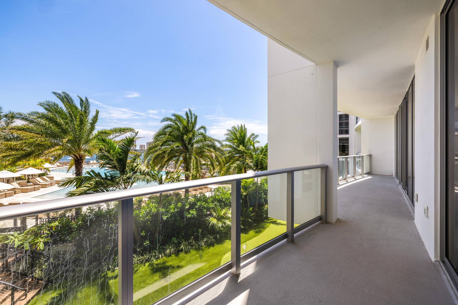 220 Lake Shore Drive, #704, Lake Park, FL 33403 Expansive balcony with concrete flooring, glass panel railing, and large sliding glass doors