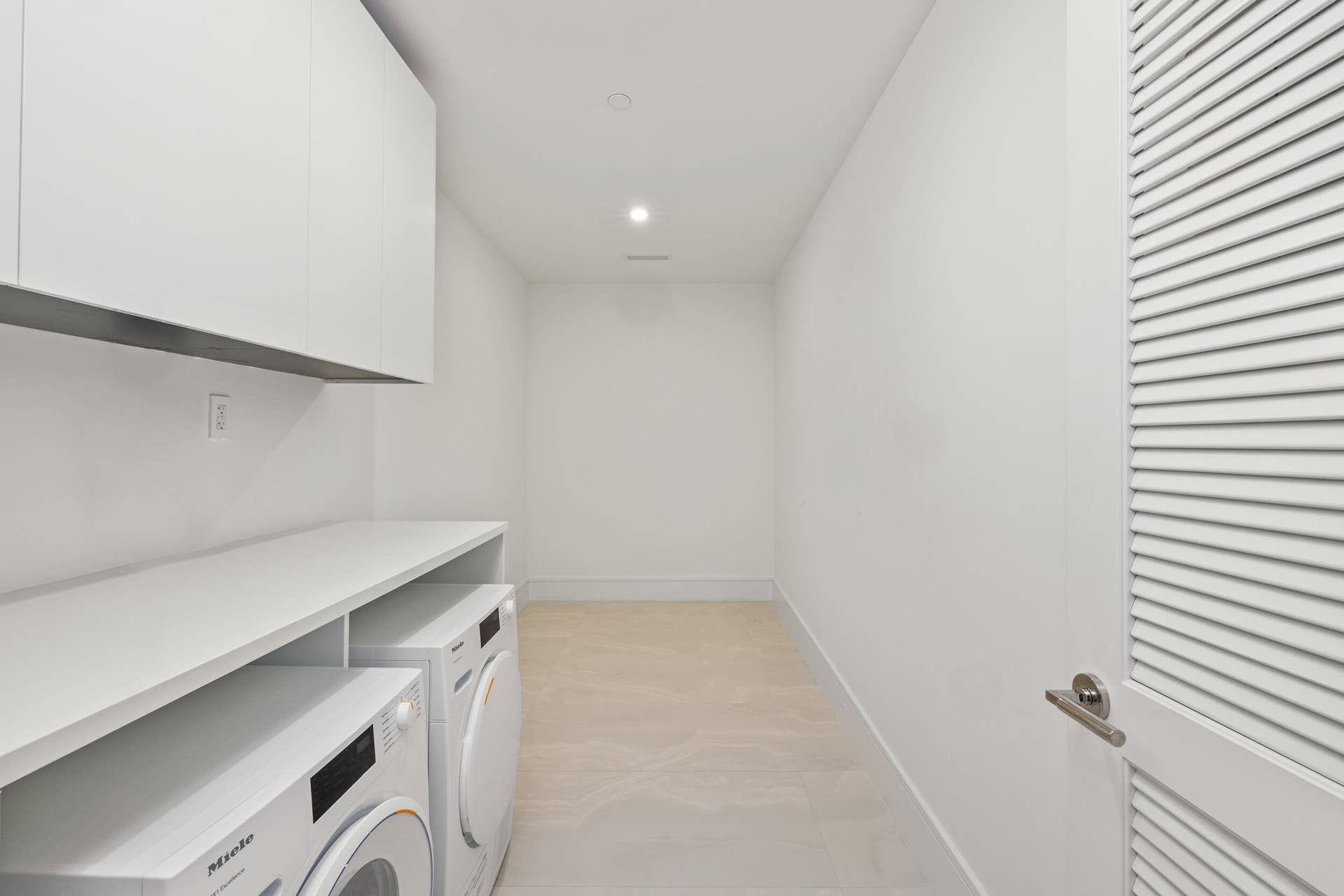 220 Lake Shore Drive, #704, Lake Park, FL 33403 Large Laundry area featuring recessed lighting, a built-in countertop, white upper cabinetry, and light-toned flooring