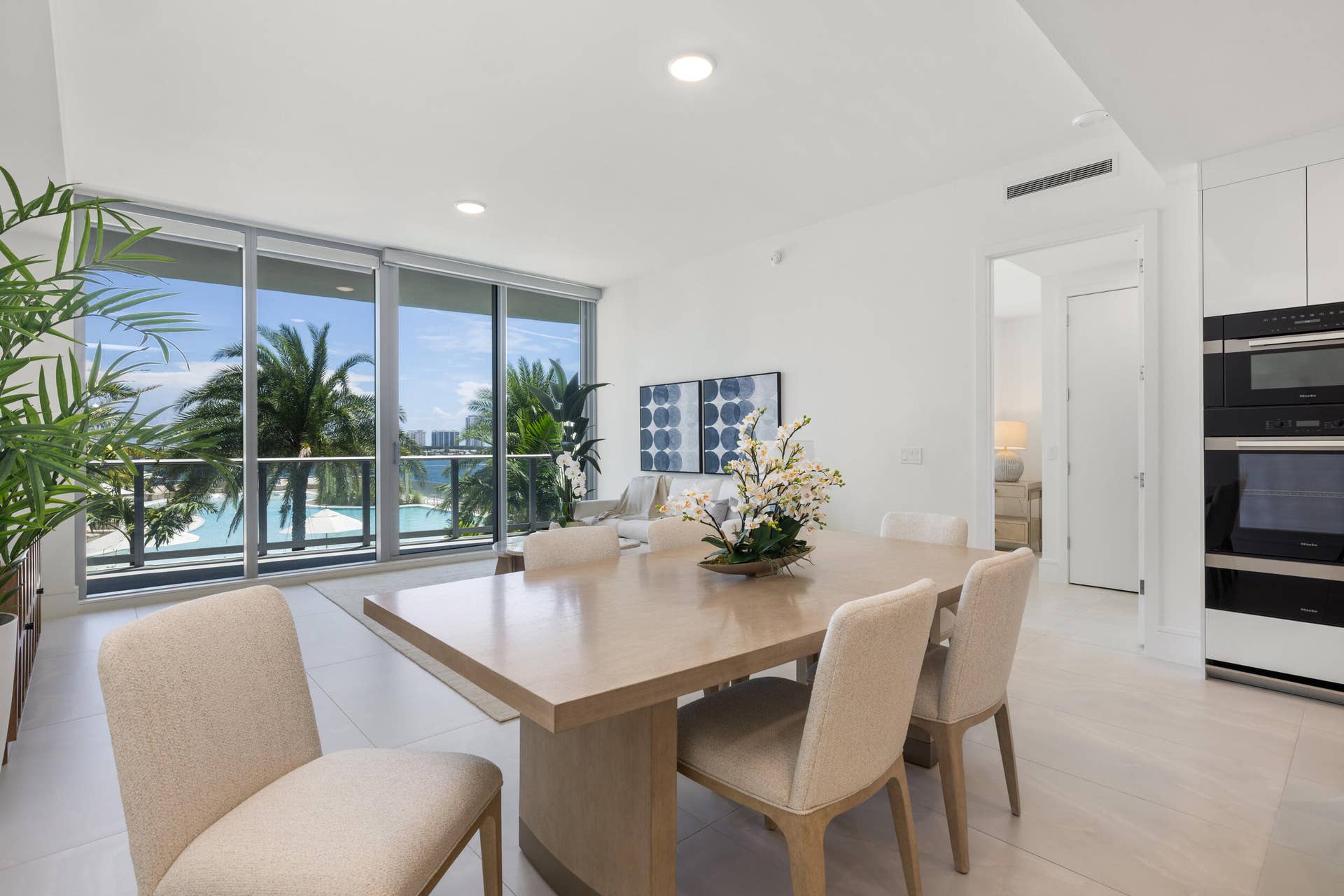 220 Lake Shore Drive, #704, Lake Park, FL 33403 Floor-to-ceiling windows, recessed lighting, white cabinetry with integrated appliances, wood-finish dining table, and tile flooring