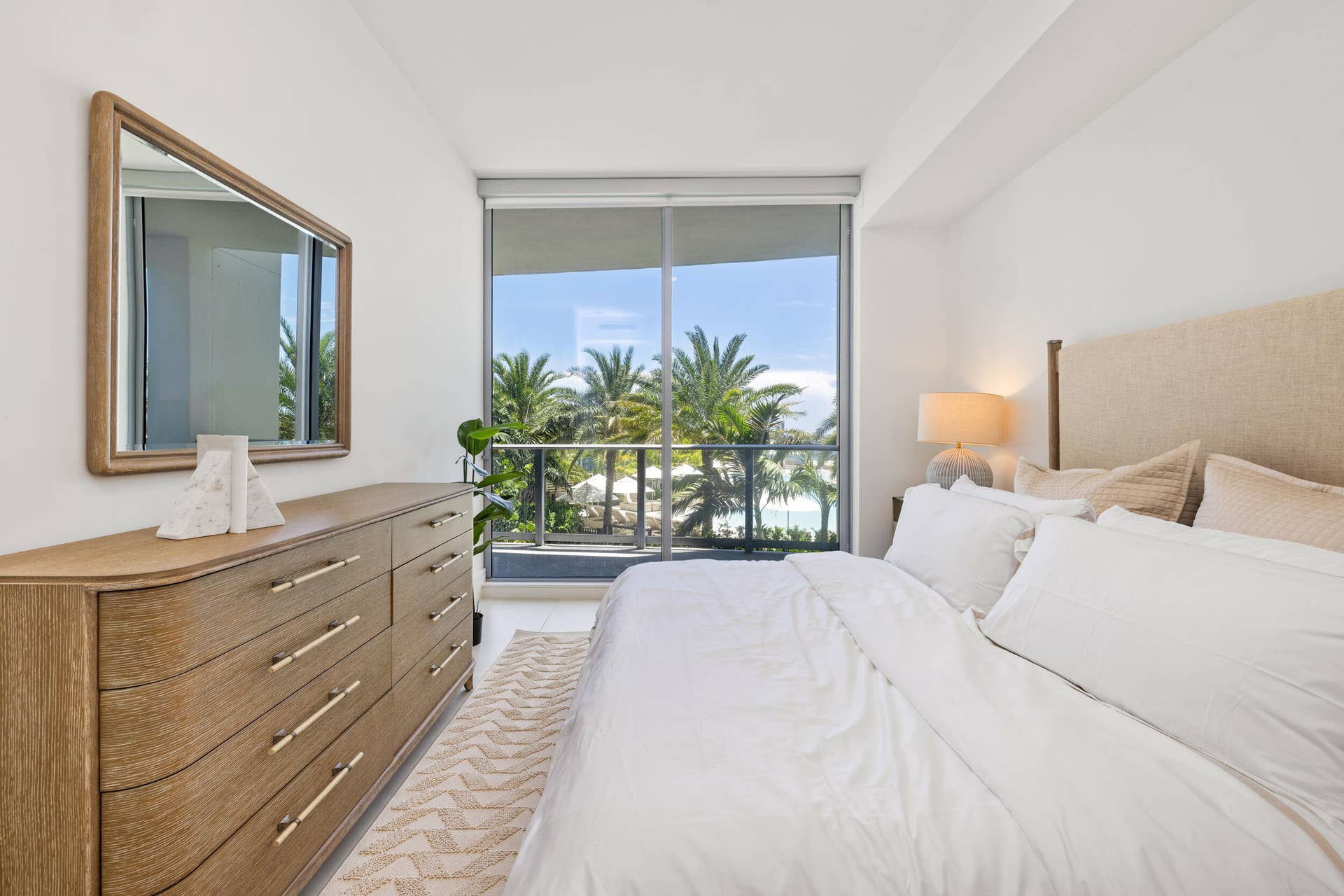 220 Lake Shore Drive, #704, Lake Park, FL 33403 Floor-to-ceiling windows, outdoor balcony, water element, and lush tropical landscaping