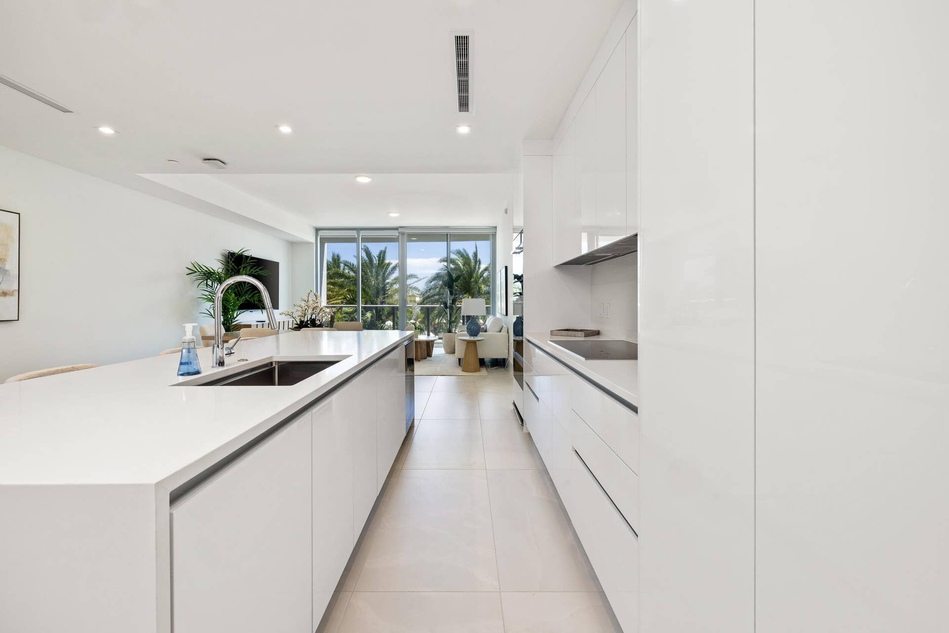 220 Lake Shore Drive, #704, Lake Park, FL 33403 Gourmet kitchen featuring a waterfall island, integrated sink, flat-panel cabinetry, and recessed lighting