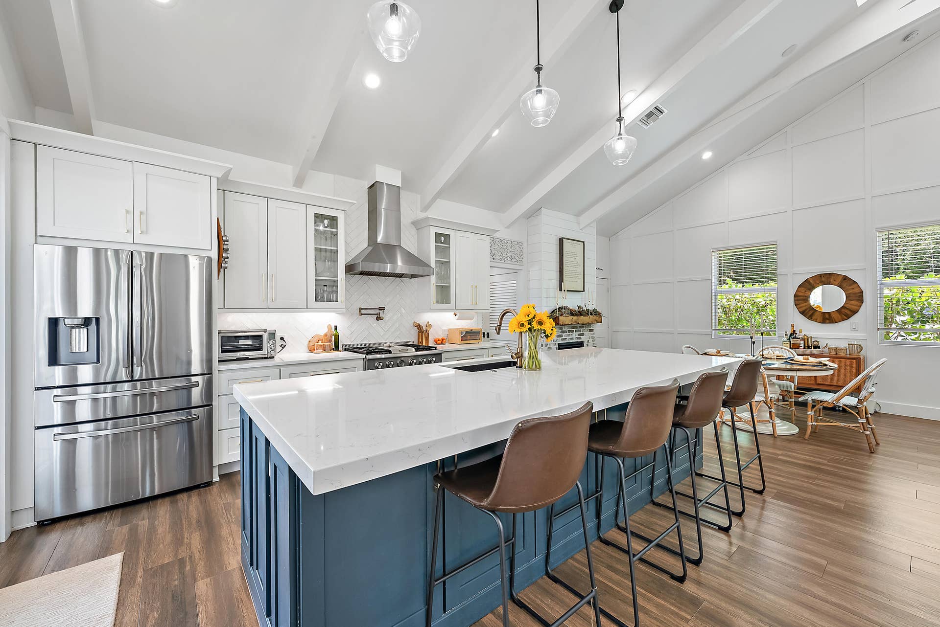 6204 SAND PINE Court, Jupiter, Jupiter, FL 33458 Vaulted ceiling with exposed beams, stainless steel appliances, central island with seating, pendant lighting, and wood-finish flooring