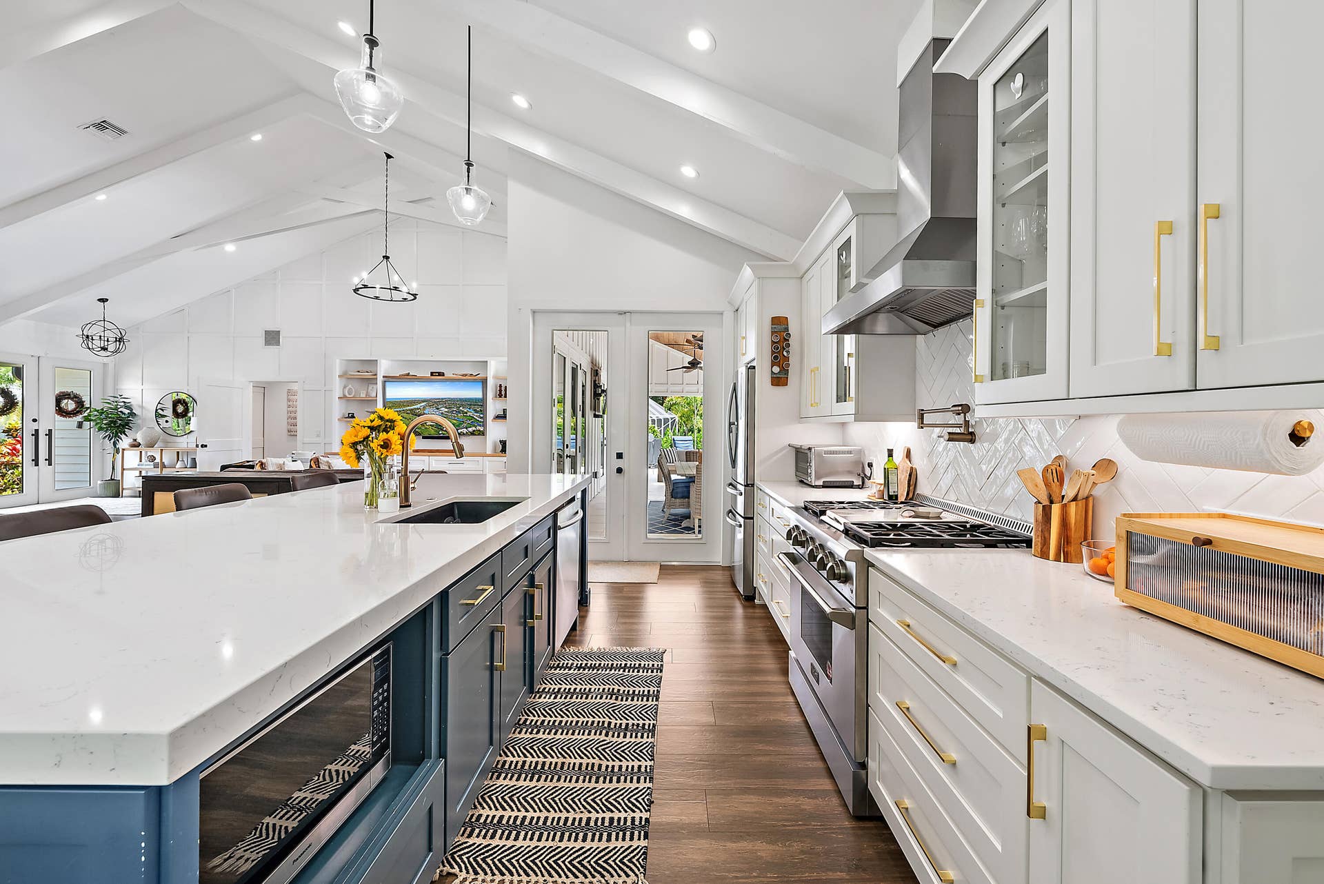 6204 SAND PINE Court, Jupiter, Jupiter, FL 33458 Open-concept kitchen with vaulted ceilings, recessed lighting, wood-finish flooring, a kitchen island with built-in microwave, and stainless steel appliances