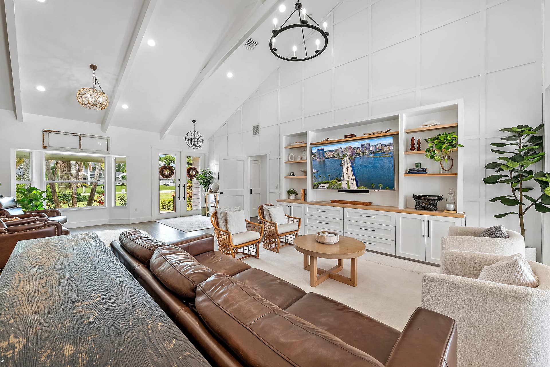 6204 SAND PINE Court, Jupiter, Jupiter, FL 33458 Vaulted ceiling with exposed beams, wood-look tile flooring, built-in entertainment center with open shelving, double entry doors, and large windows