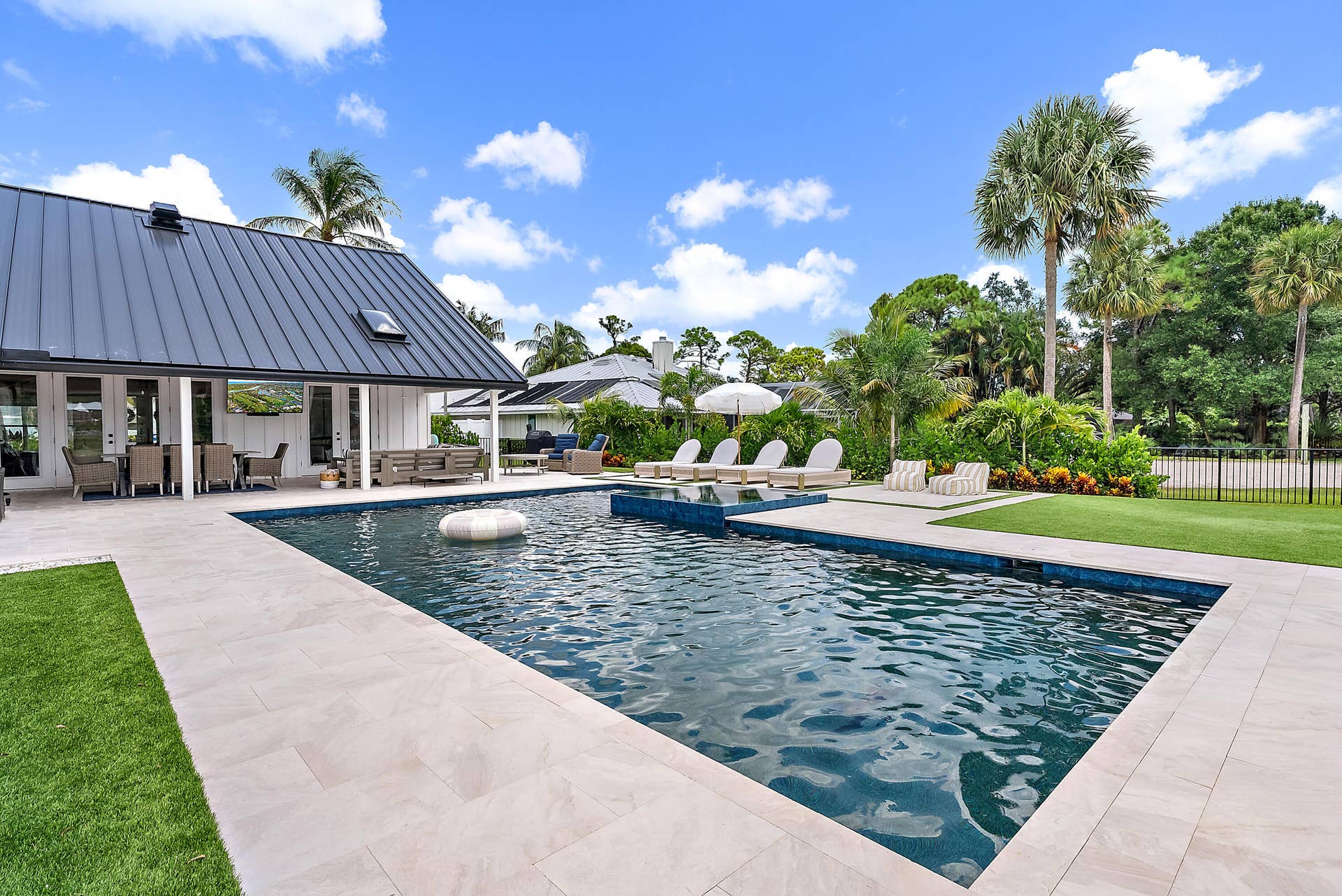 6204 SAND PINE Court, Jupiter, Jupiter, FL 33458 Expansive outdoor living area featuring a large swimming pool, surrounding paver patio, and lush landscaping