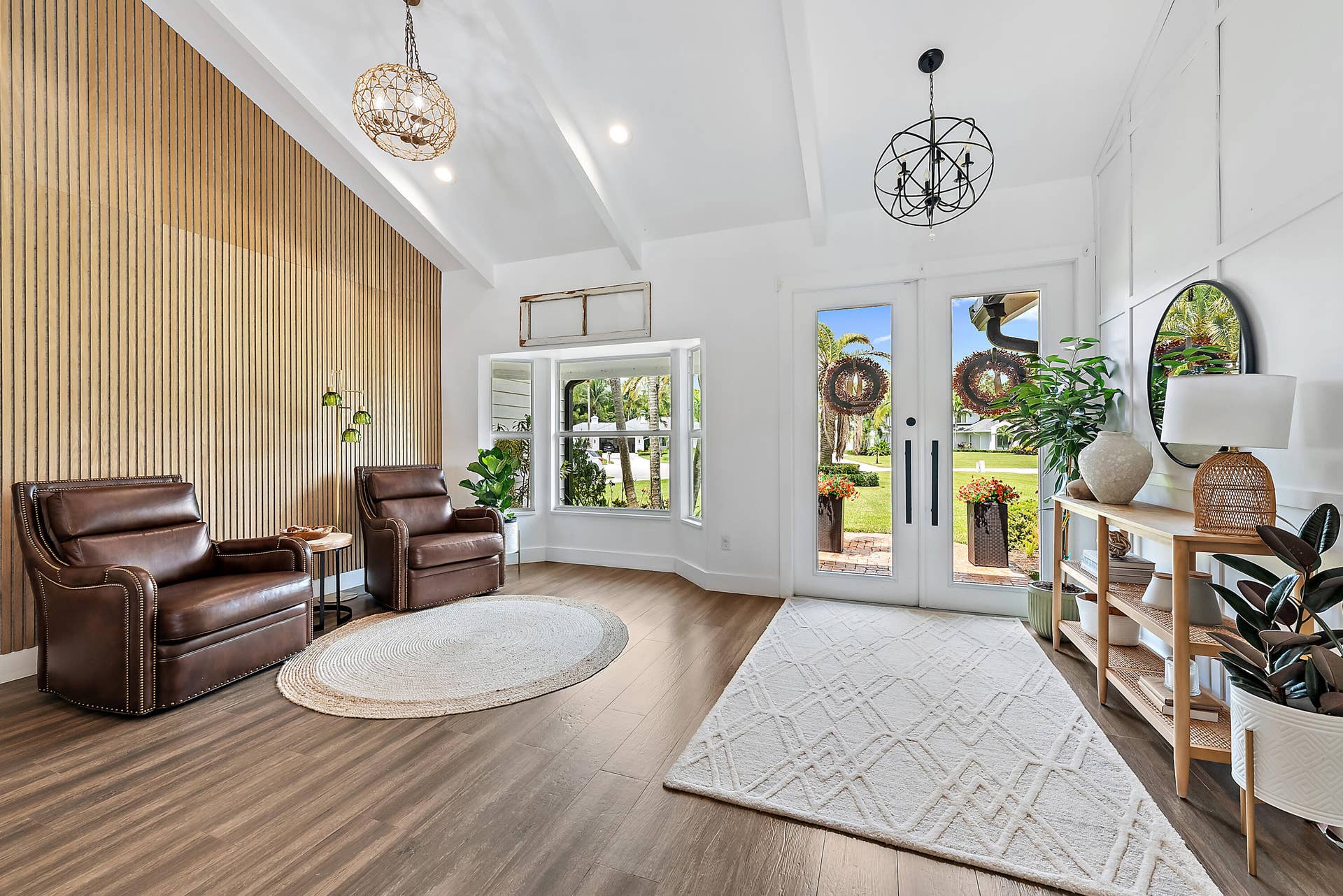 6204 SAND PINE Court, Jupiter, Jupiter, FL 33458 Vaulted ceiling with exposed beams, wood-look tile flooring, accent wall with vertical wood paneling, dual glass-paneled entry doors, and built-in window seating