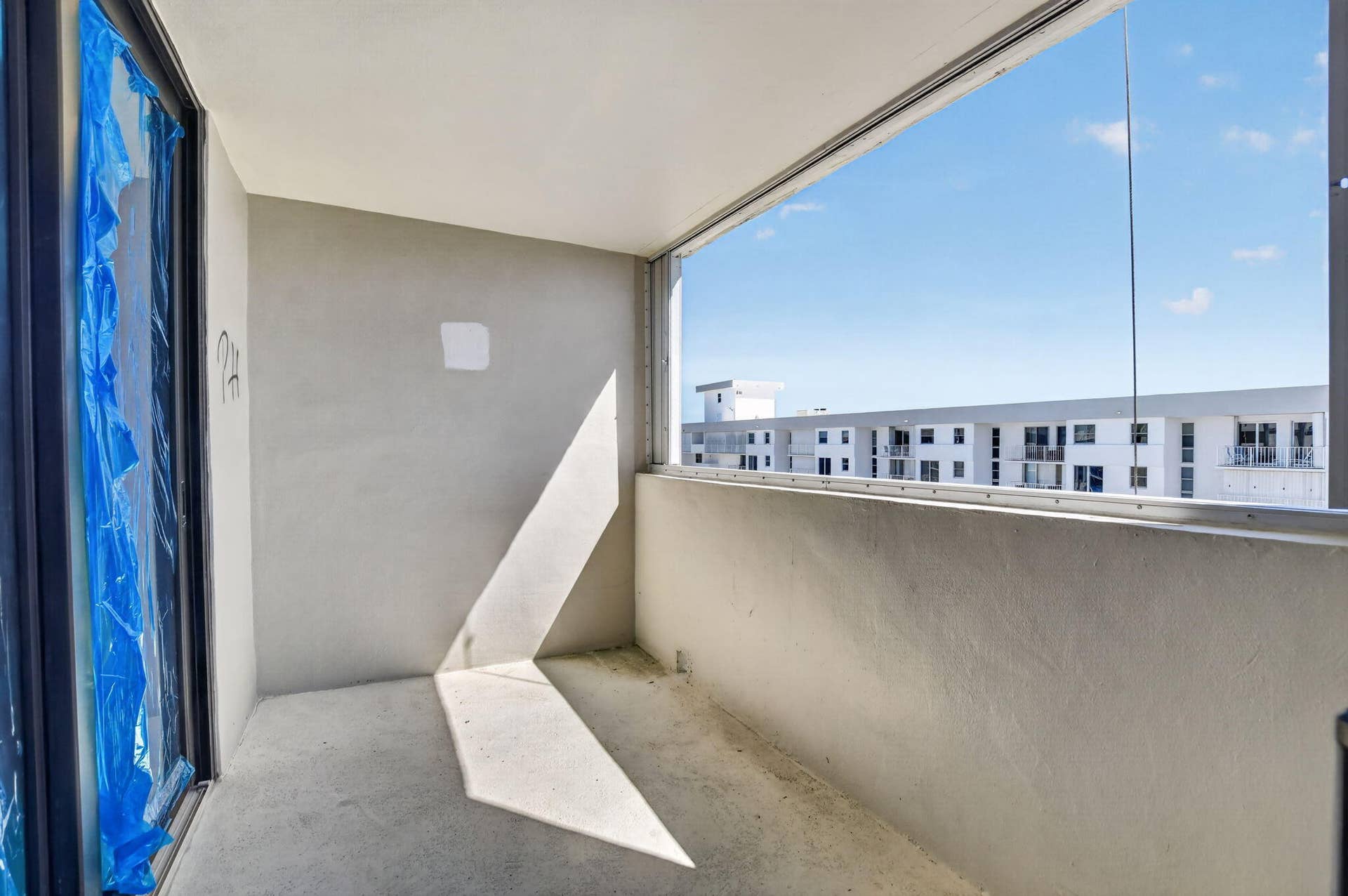 Balcony 1 has views of ocean, blue film for construction purposes.