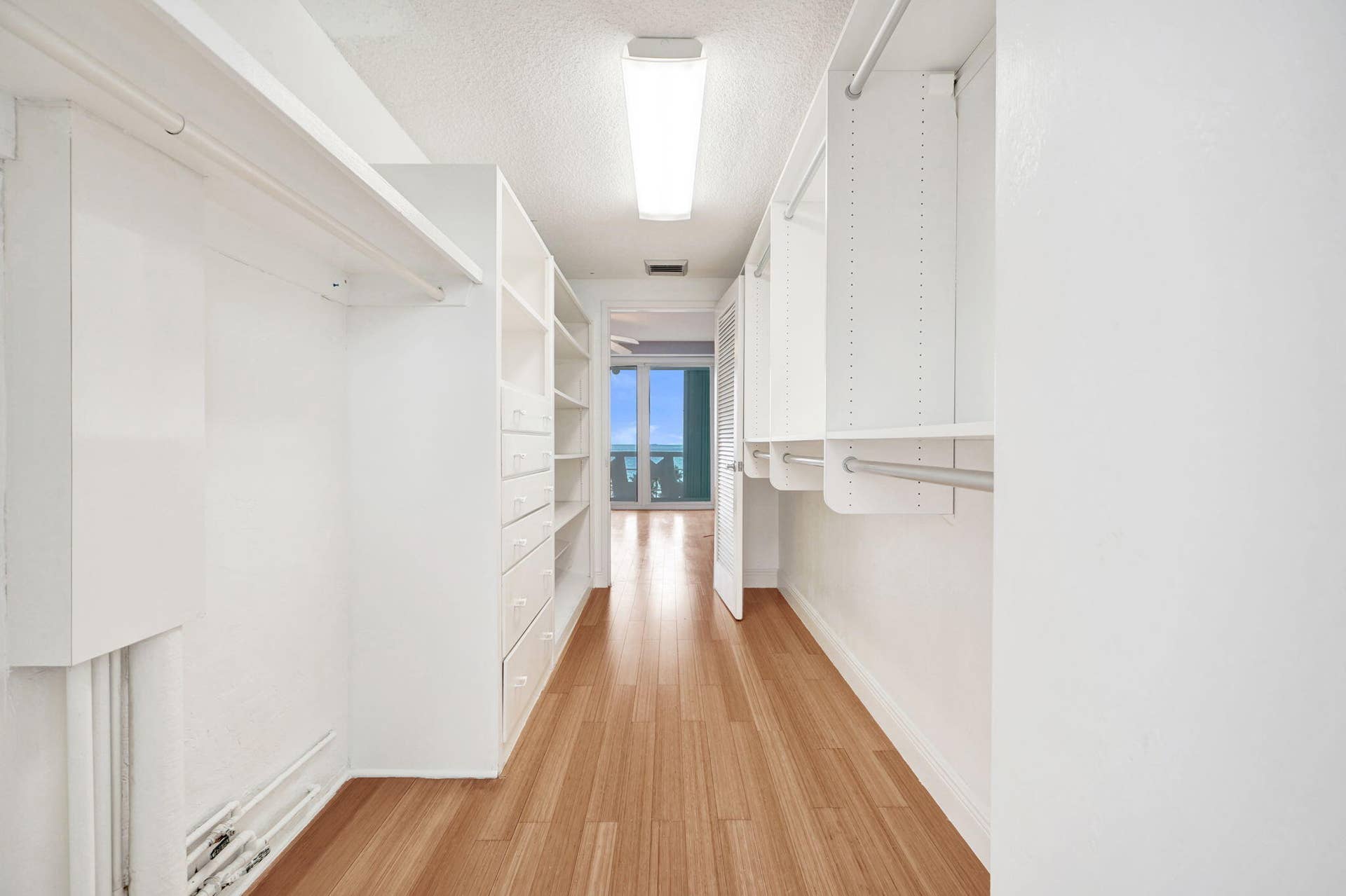 WALK IN CLOSET FACING EAST TO BEDROOM